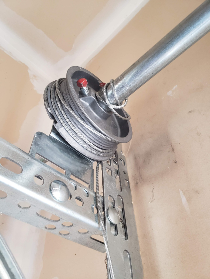 A professional technician performing garage door cable repair to ensure safety and smooth operation.