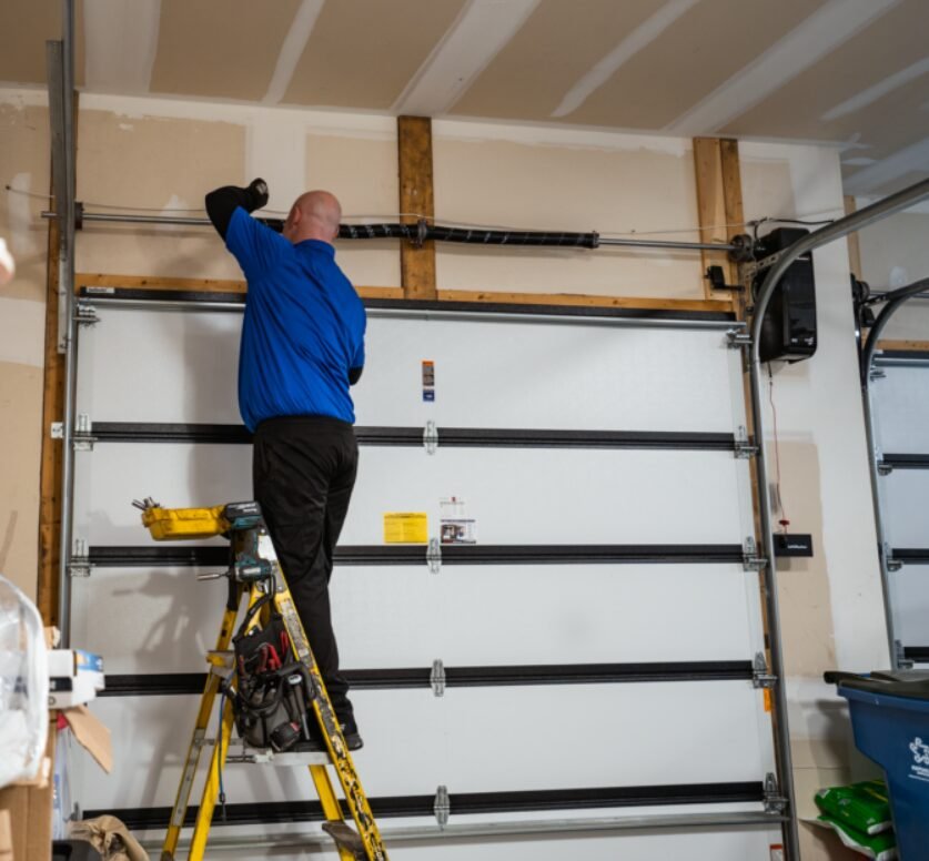 Close-up image of a technician performing garage door spring repair at a residential property, showcasing the tools and techniques used by Garage Door Repair Foxleigh LLC.