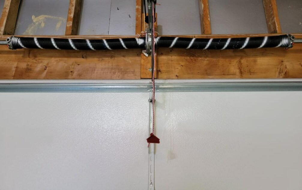 a technician performing a garage door spring repair, showcasing a well-maintained garage door with tools visible, illustrating professional repair services offered by Garage Door Repair Foxleigh.